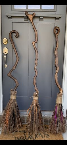 two brooms sitting in front of a door