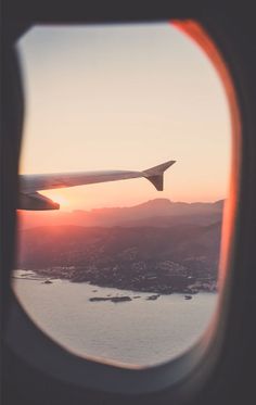 the view out an airplane window at sunset