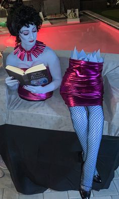 a woman sitting on a bench with a book in her lap and wearing fishnet stockings