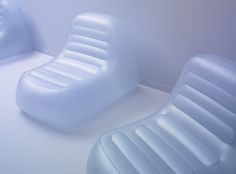 two inflatable chairs sitting next to each other on a white floor with blue walls