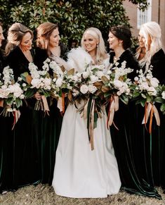 a group of women standing next to each other holding bouquets