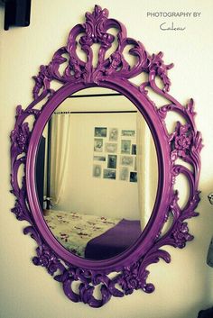 a purple mirror hanging on the side of a wall