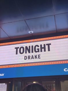 a woman standing in front of a building with a sign that says tonight drake