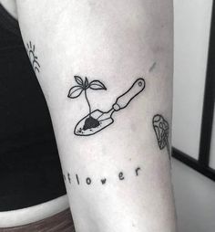 a woman's arm with a small tattoo on it that says flower and a knife