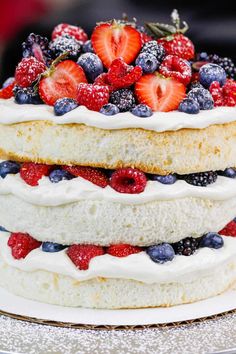 a layered cake with berries and blueberries on top