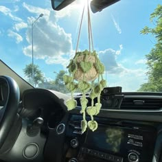 the interior of a car is decorated with green crochet and hanging from strings