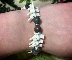 Rattlesnake vertebrae, bloodstone beads and metal beads strung on elastic cord. Bone Beads Jewelry, Serpent Bracelet, Snake Vertebrae, Gothic Bracelet, Bone Jewelry, Bone Beads, Bead Stringing, Metal Beads, Beaded Bracelet