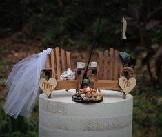 a wedding cake with two wooden chairs on top