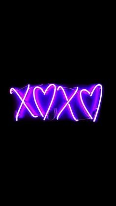 neon hearts are arranged in the shape of x on a black background