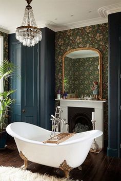 a bathtub in a bathroom with a fireplace and mirror on the wall next to it