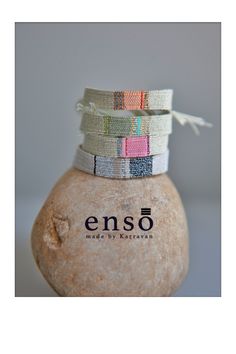 stack of bracelets sitting on top of a rock with the word enso printed on it