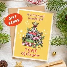 a card with a christmas tree on it next to some pine cones and other holiday decorations