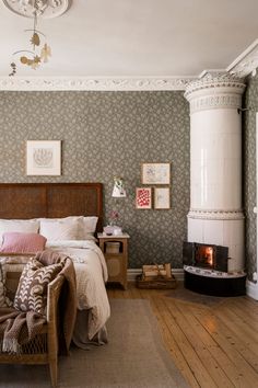 a bed sitting in a bedroom next to a fire place on top of a hard wood floor