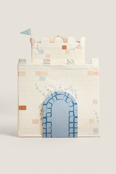 a paper model of a castle with a blue door and brick wall on the outside