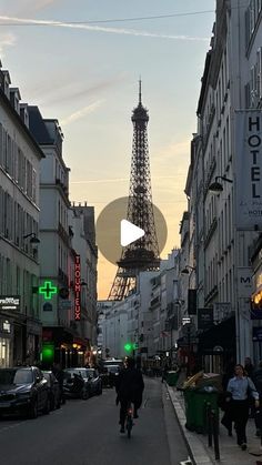 the eiffel tower is in the distance as people walk down the street