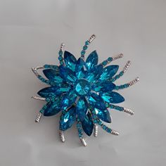 2 1/2 Inch Sparkly Blue Brooch Small Curved Arms With Tiny Ble Stones. Clip On The Back Great Gift Or For Your Self Comes Boxed Blue Crystal Brooch Jewelry, Blue Crystal Jewelry Brooch, Blue Crystal Jewelry With Brooch Detail, Blue Brooch For Wedding Jewelry, Blue Wedding Brooch Jewelry, Blue Crystal Brooches For Gifts, Blue Flower-shaped Formal Jewelry, Blue Flower Brooch For Wedding, Formal Blue Flower Brooch