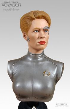 a close up of a statue of a woman wearing a silver suit and red lipstick