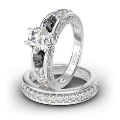 two white gold wedding rings with diamonds on each one and an engagement ring in the middle