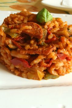 a white plate topped with rice covered in meat and vegetables