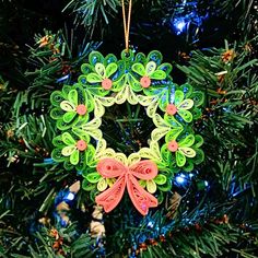 an ornament hanging from a christmas tree in the shape of a wreath with bows