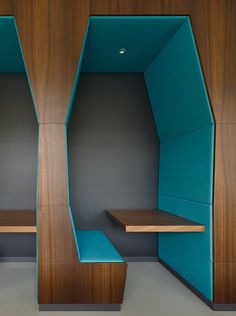 an empty room with wooden shelves and blue chairs