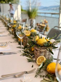 the table is set with lemons and greenery for an elegant dinner or party