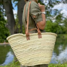 Discover artisanal elegance with our hand-woven wicker bag in the heart of the souks of Marrakech. Made from natural white palm leaves, this bag combines ecology, ethics and timeless style. This bag is a must-have for those looking for a chic and eco-friendly accessory. A true treasure of craftsmanship, this basket is meticulously hand-woven in Marrakech by passionate artisans. The large leather handles are long (40 cm) and allow the bag to be carried on the shoulder. The stitching is reinforced Traditional Summer Bags With Leather Handles, Summer Market Straw Bag With Bamboo Handle, Natural Color Basket-shaped Straw Bag For Shopping, Natural Basket-shaped Straw Bag For Shopping, Summer Straw Bag With Leather Handles For Market, Natural Basket Straw Bag For Market, Market Straw Bag With Handles, Basket Straw Bag With Braided Handles For Market, Market Basket Straw Bag With Braided Handles