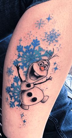 a tattoo with a cartoon character and snowflakes on it's leg,