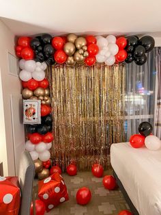 a bedroom decorated with balloons and streamers in red, black, white and gold colors