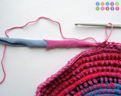 a crocheted piece of cloth next to a knitting needle