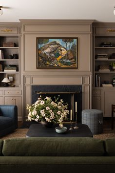 a living room filled with furniture and a painting on the wall above a fire place