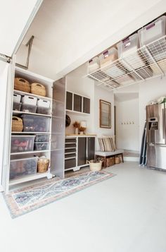 a room with several shelves and baskets on the floor in front of a refrigerator freezer