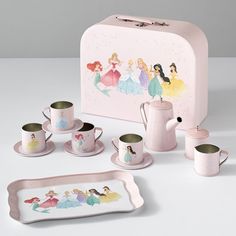 a pink lunch box with princesses on it and other items in front of it