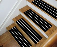 the stairs are lined with black and white striped carpet