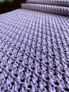 two crocheted bedspreads are laying on top of each other in purple