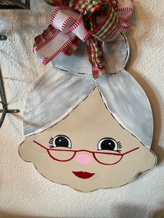 a paper doll with glasses and a bow on it's head is hanging from the wall