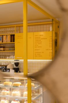 a bakery with yellow walls and shelves filled with cakes