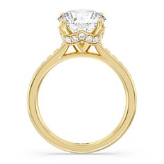 a yellow gold engagement ring with an oval center stone and side stones on the sides