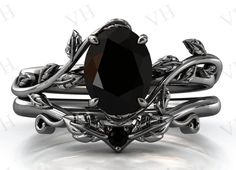 an intricately designed black diamond ring with vines and leaves on the sides, set in 18k white gold