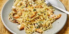 a plate of pasta with shrimp and parsley