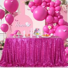 there is a table with pink balloons on it