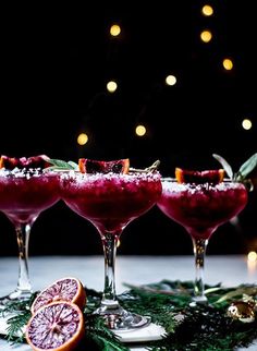 three wine glasses filled with blood oranges and garnish