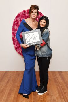 two women standing next to each other holding an award