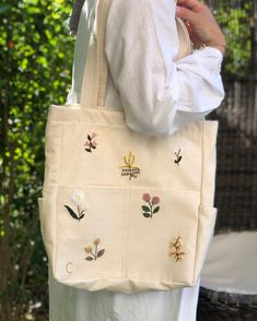 Since I am currently working on the bags from a different location during the summer vacation, I had to extend the delivery time of my eco shipments a little more. However, by paying $9, I can have your orders delivered as quickly as possible via express shipping. I would be very happy if you could understand🫶✨ Hand embroidered large tote bags with inner pockets 💖For your personalized gifts these bags are eco friendly and great for daily use!🎁 Great gift for special person💝  It is a gift, pe Arm Sling, Sac Tote Bag, Stylish School Bags, Flower Tote Bag, Flower Tote, Embroidered Tote, Romantic Gestures, Bag With Zipper, Embroidery Motifs