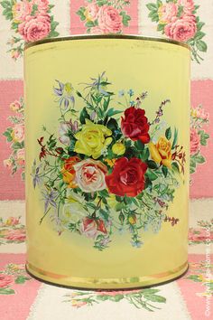 a yellow tin with flowers painted on it