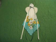 a pair of crochet hooks are laying on a green quilted bedspread