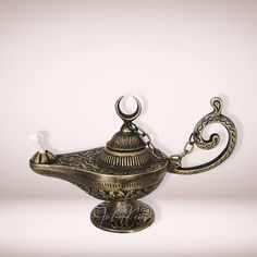 an ornate metal bowl with a hook on it