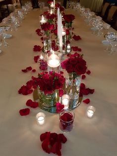 a long table with candles and roses on it