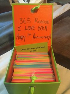 an open box filled with lots of cards and writing on the inside, sitting on top of a bed