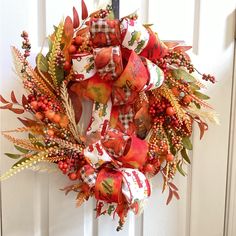 a wreath on the front door decorated with autumn leaves and berries is ready to be hung